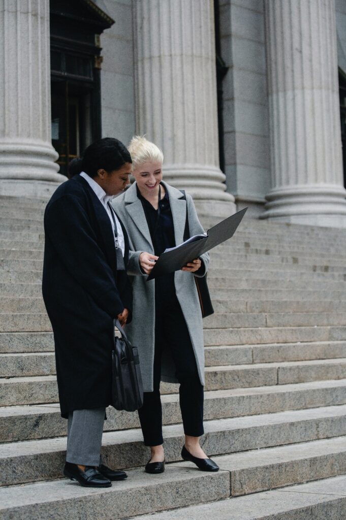 Corporate lawyers discussing their case details outside the courthouse.