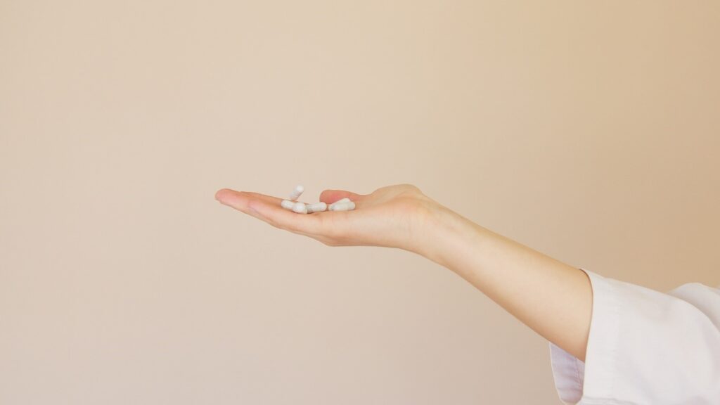 consumer holding out dietary supplement pills