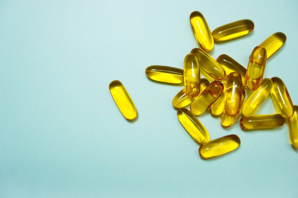 golden dietary supplements on a blue surface
